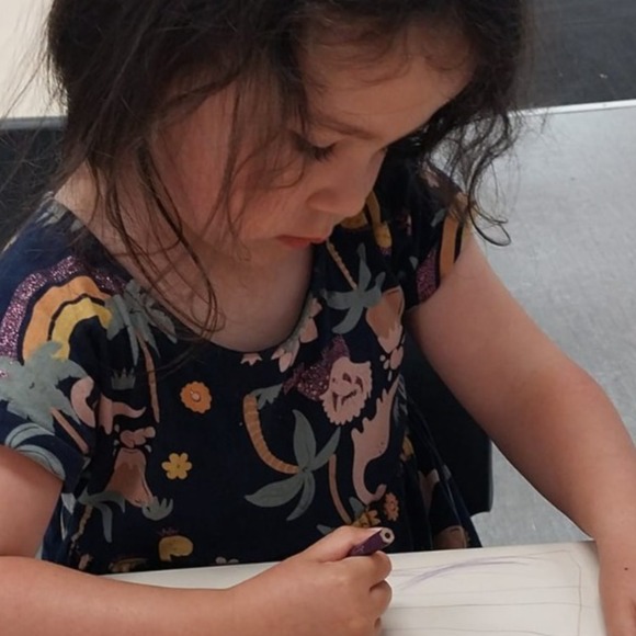 A photorealistic image depicting a culturally inclusive child care classroom in New Zealand. Children of various ethnic backgrounds engage in artistic activities that include Māori cultural elements. The room is decorated with traditional Māori motifs and vibrant art, promoting a sense of community and belonging.